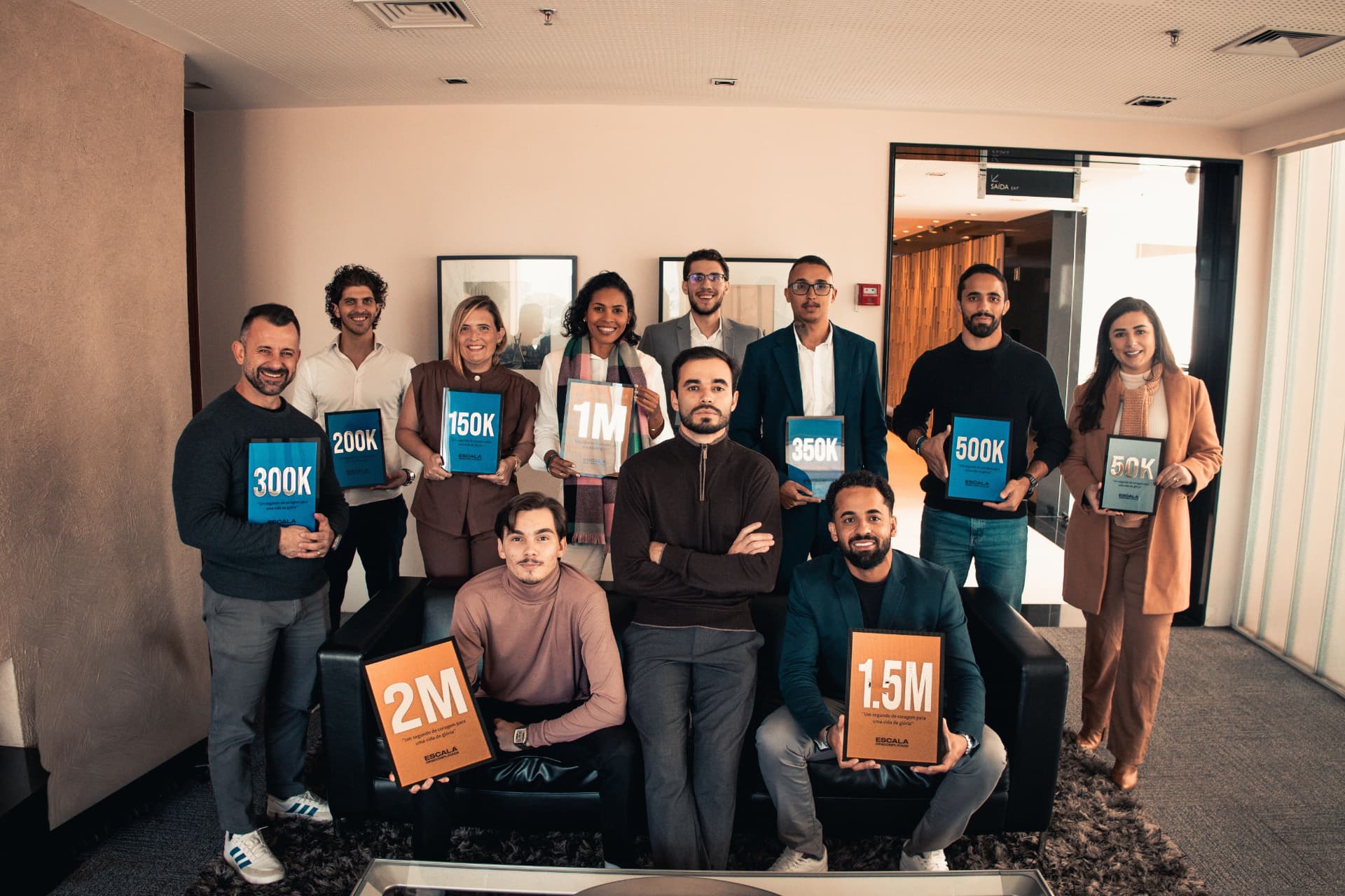 Equipe de mentores segurando painéis com resultados de faturamento